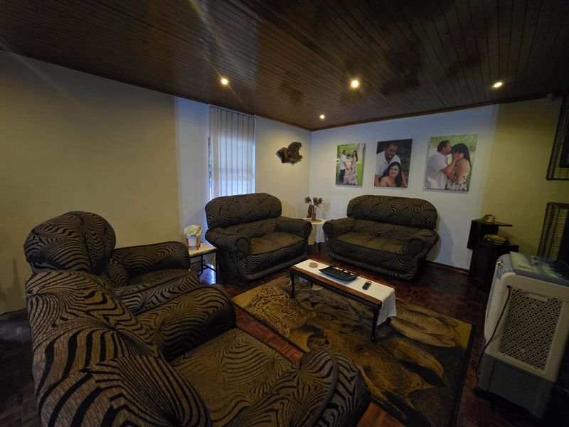 A cozy living room featuring warm timber ceiling paneling, classic parquet flooring, and recessed lighting, creating a comfortable and inviting atmosphere.
