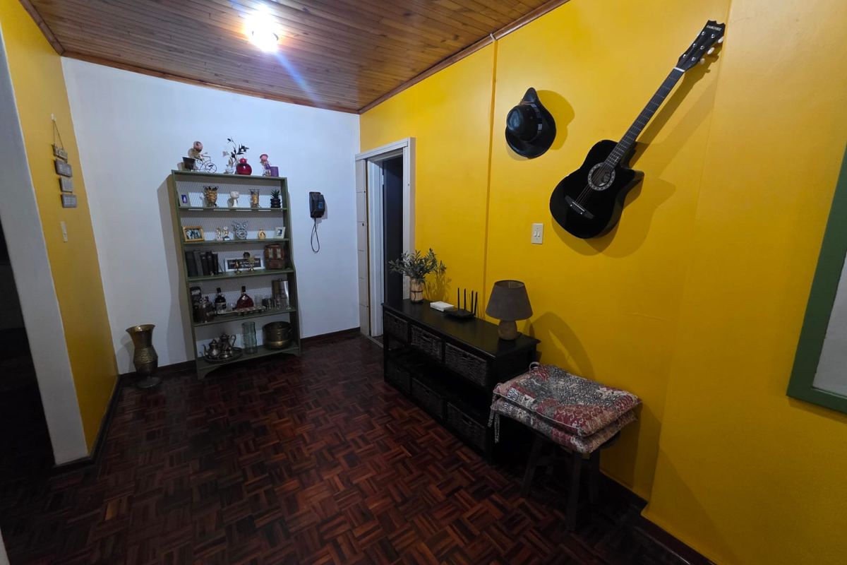 A living area featuring traditional parquet flooring and a timber-paneled ceiling, providing a warm and classic foundation for interior design updates.