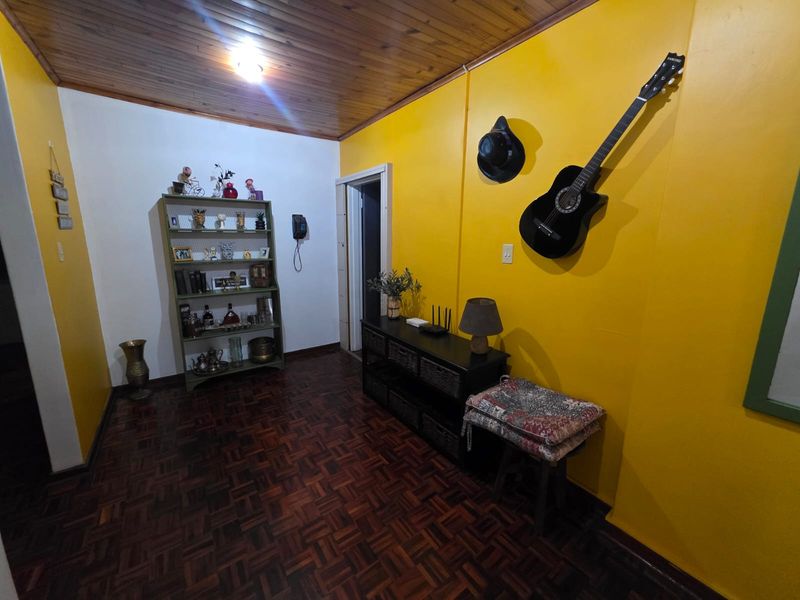 A living area featuring traditional parquet flooring and a timber-paneled ceiling, providing a warm and classic foundation for interior design updates.