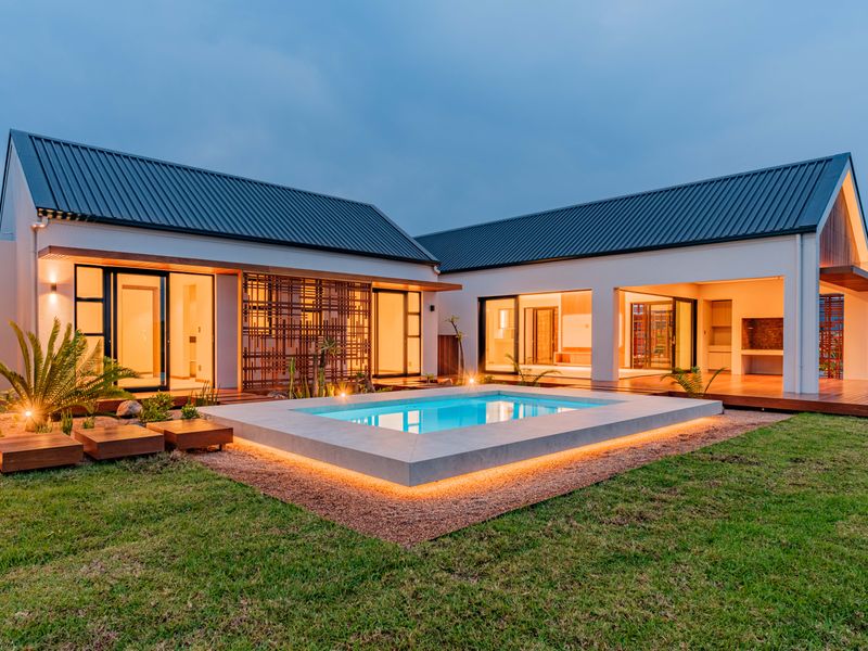 Modern architectural home featuring a central swimming pool, timber decking, and seamless indoor-outdoor flow with integrated outdoor entertainment area.