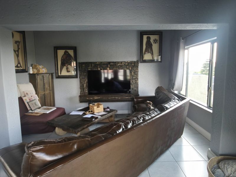 A living room featuring tiled flooring and a decorative built-in fireplace surround, offering a comfortable space for relaxation.
