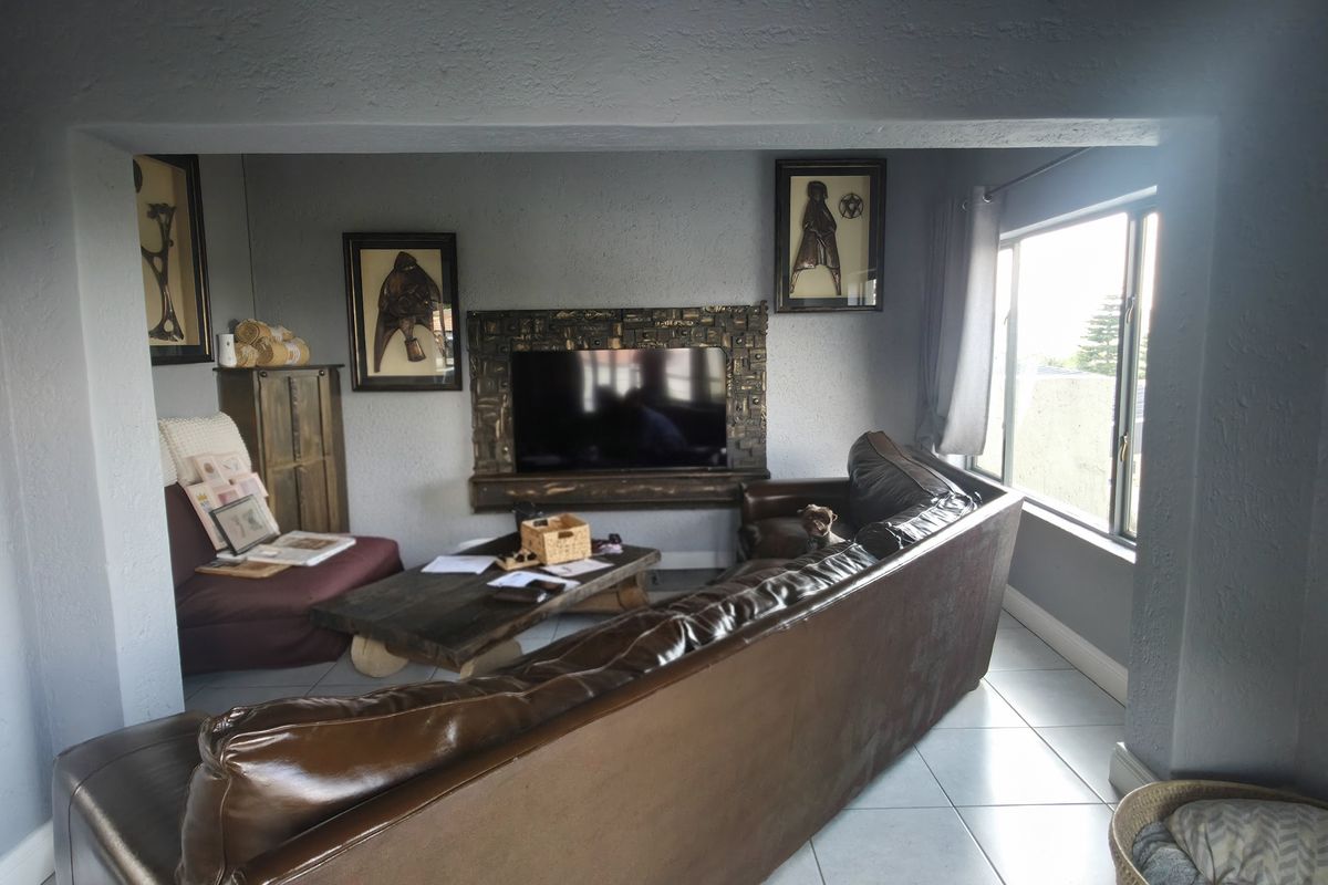 A living room featuring tiled flooring and a decorative built-in fireplace surround, offering a comfortable space for relaxation.