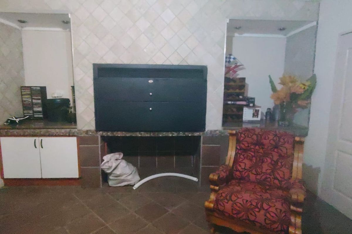 Living area featuring a built-in fireplace with tiled splashback, granite countertops, and integrated cabinetry.
