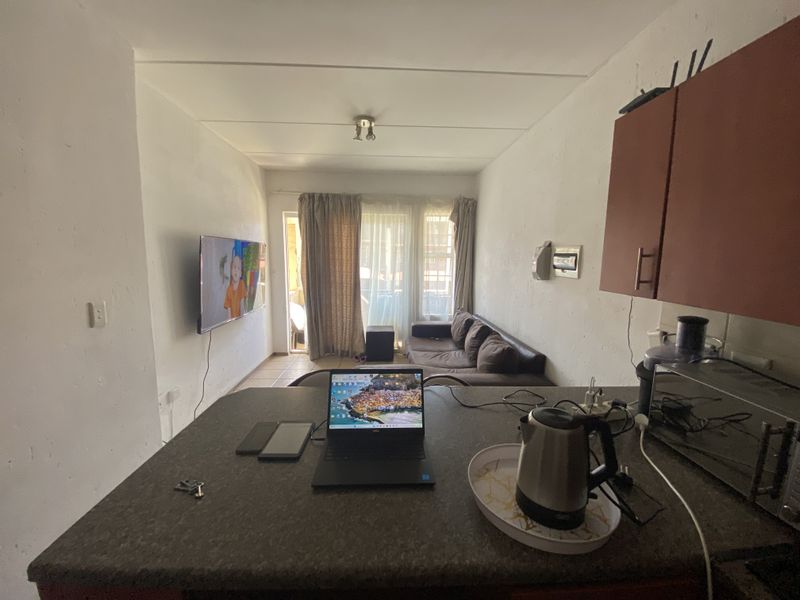 Open plan living area featuring a kitchen breakfast bar and direct access to a patio through sliding glass doors.