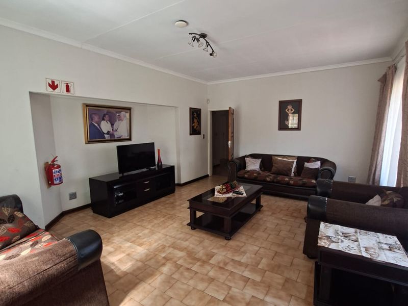 A spacious living room featuring ceramic tile flooring and a recessed wall niche, providing a functional and comfortable living area.