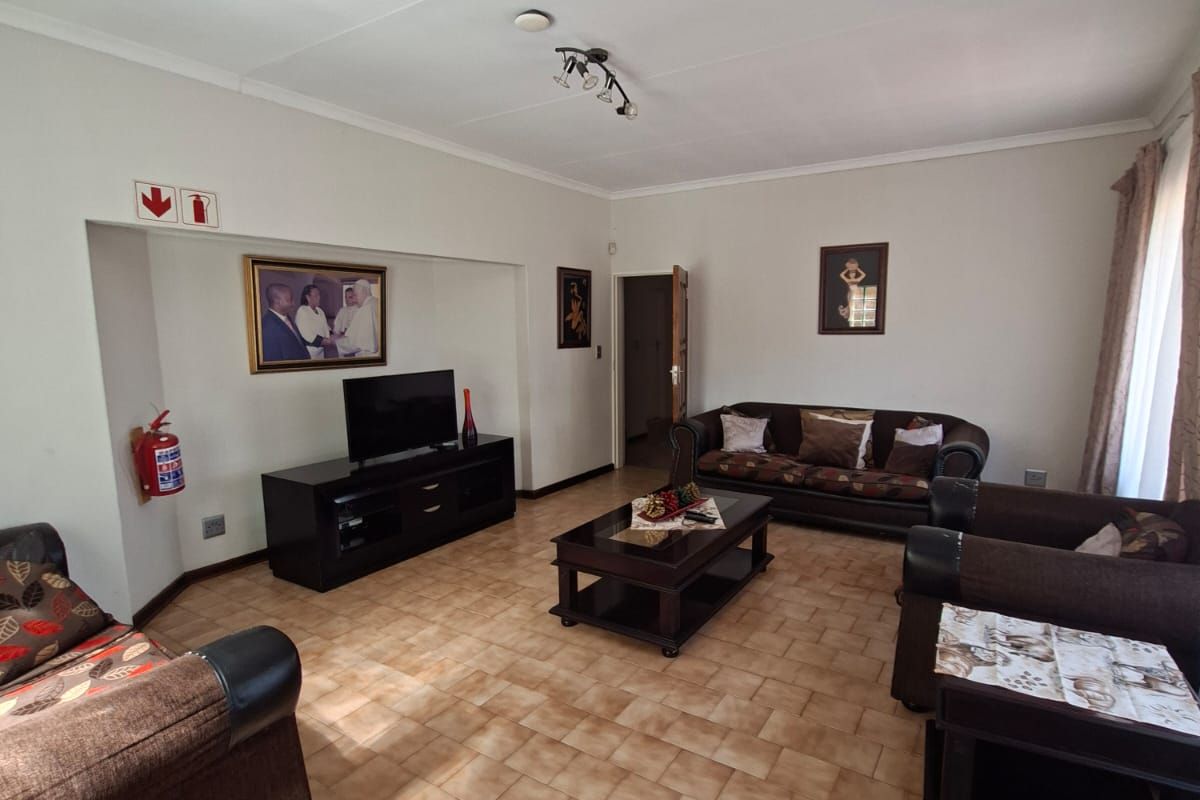 A spacious living room featuring ceramic tile flooring and a recessed wall niche, providing a functional and comfortable living area.