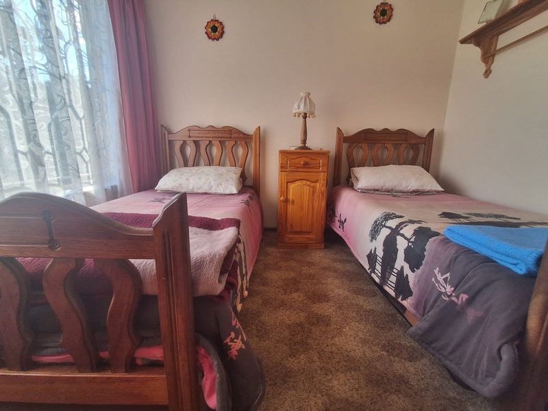 A functional bedroom featuring carpeted flooring and window treatments, offering a comfortable space with potential for modern updates.