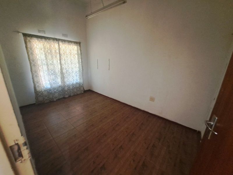 An empty bedroom featuring tiled flooring and neutral walls, providing a blank canvas for personalization and interior design updates.