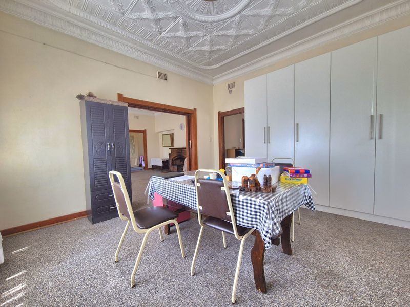 Spacious bedroom featuring classic ornate pressed metal ceilings and extensive built-in cupboard storage, offering a solid foundation for cosmetic updates.