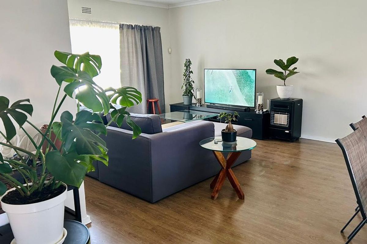 A comfortable living room featuring laminate flooring and a built-in gas heater, offering a functional and inviting space for relaxation.