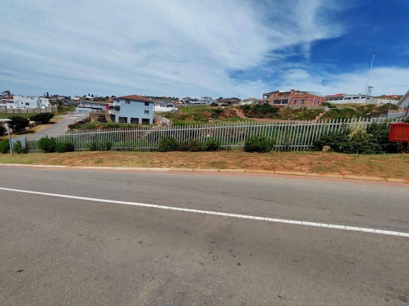 Street view of a vacant residential plot secured with metal palisade fencing, situated in an established neighborhood.