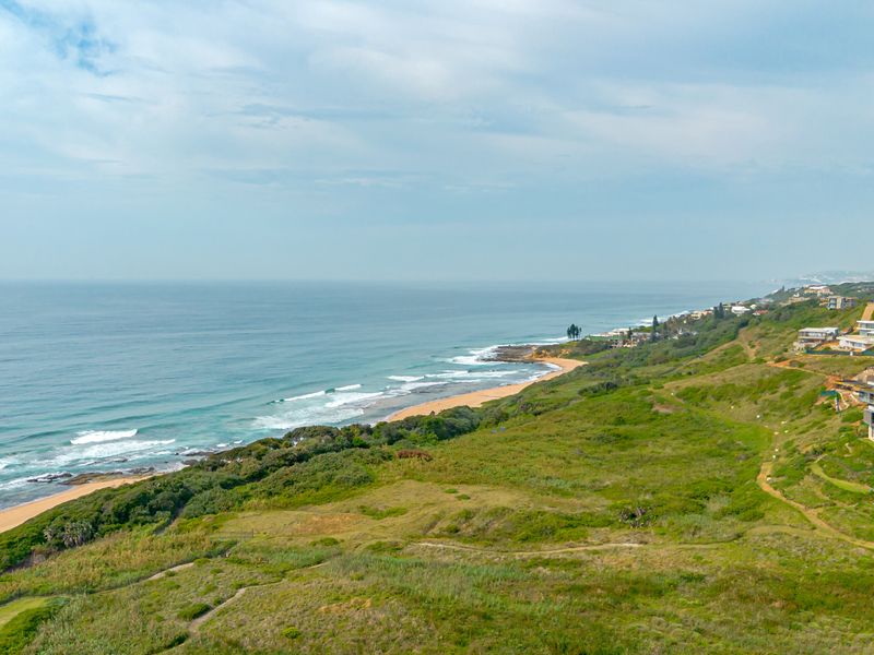 An elevated aerial view of the coastal landscape, showcasing the natural terrain and proximity to the ocean.