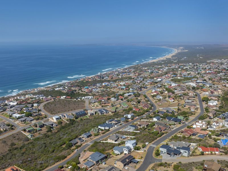 An elevated aerial view of a coastal residential neighborhood, showcasing the proximity to the ocean and the surrounding landscape.