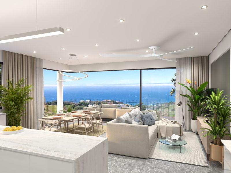 Modern open-plan living and dining area featuring a sleek kitchen island, recessed lighting, and expansive sliding glass doors showcasing panoramic ocean views.