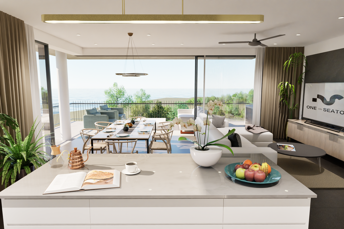 Modern open-plan living and kitchen area featuring a sleek island, recessed lighting, and expansive sliding doors opening to a balcony with ocean views.