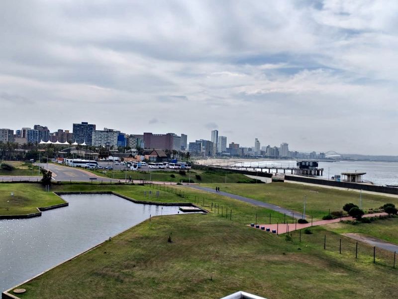 Elevated coastal view overlooking the surrounding parkland, canal, and city skyline from a private balcony.