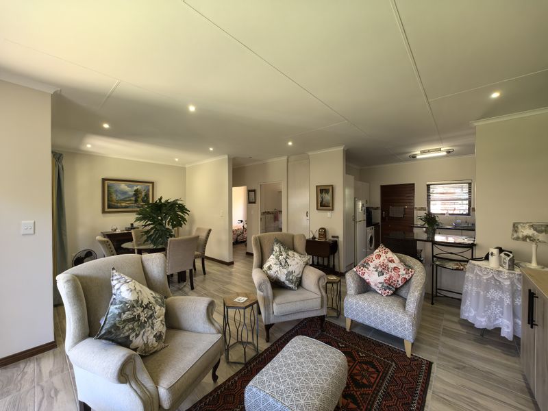 Spacious open-plan living and dining area featuring modern tiled flooring, recessed lighting, and a functional kitchen with a breakfast bar.