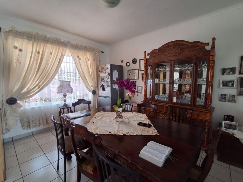 A dining room featuring tiled flooring and classic ceiling cornicing, providing a functional space for family meals.