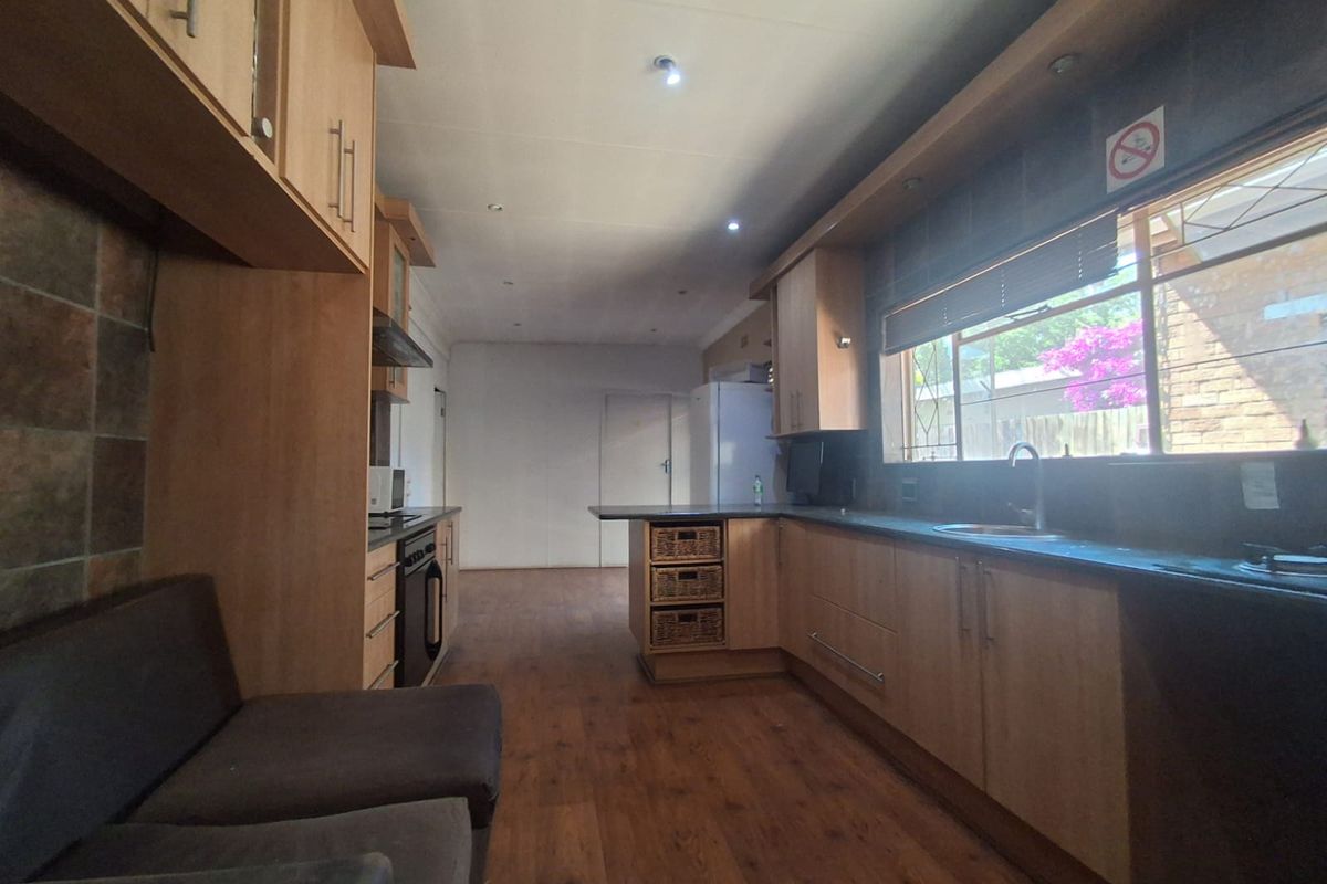 A functional kitchen featuring wood-finish cabinetry, laminate countertops, integrated appliances, and recessed lighting, offering a practical layout with ample storage space.
