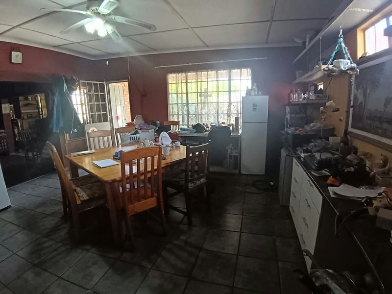 Open plan living and dining area featuring tiled flooring, ceiling fan, and built-in cabinetry, offering a functional space with potential for modernization.