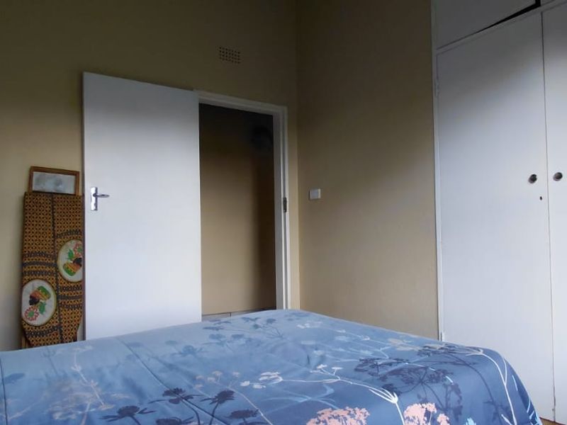A standard bedroom featuring a built-in wardrobe and neutral wall finishes, offering a functional space ready for personalization.