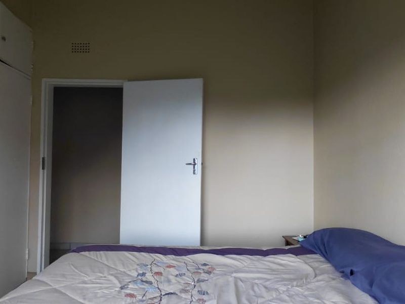 A bedroom featuring built-in cupboards and a ventilation grille, requiring cosmetic updates to improve the overall aesthetic and condition of the space.