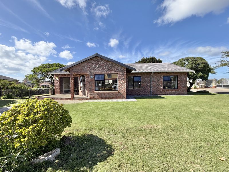 A well-maintained single-story face brick house featuring a tiled roof, paved patio area, and established front lawn.