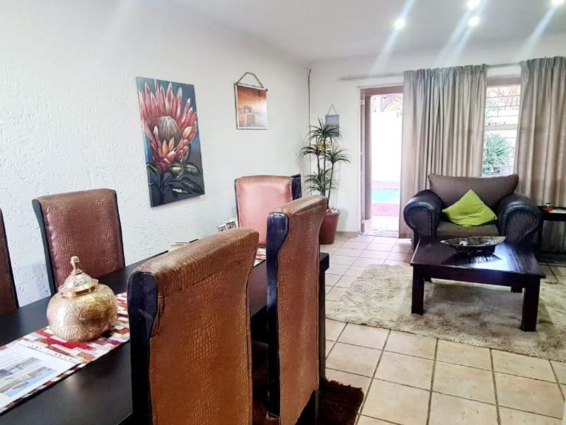 An open-plan living and dining area featuring tiled flooring, recessed lighting, and a sliding glass door providing access to the outdoor space.