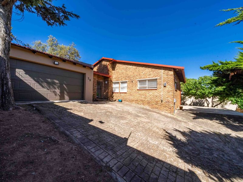 Front exterior view of a brick house featuring a paved driveway and an attached double garage.