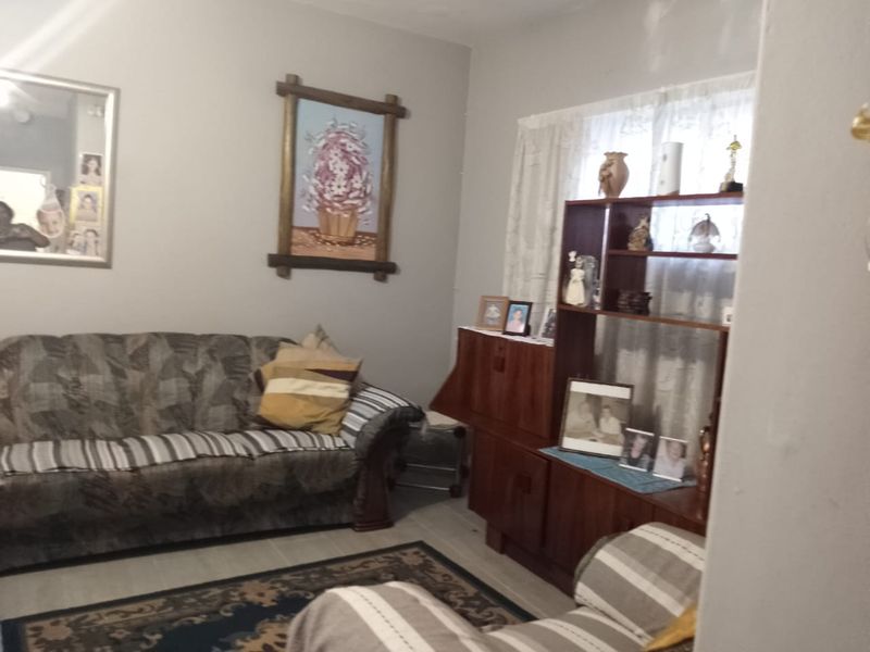 A living room area featuring laminate flooring and neutral wall finishes, providing a functional space for relaxation.