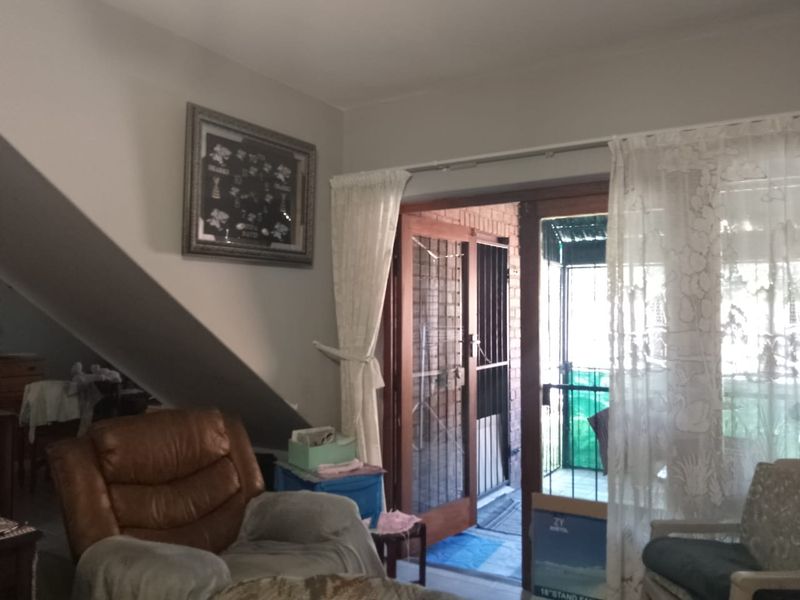 Living room area featuring a sliding glass door with security gate leading to an outdoor space.