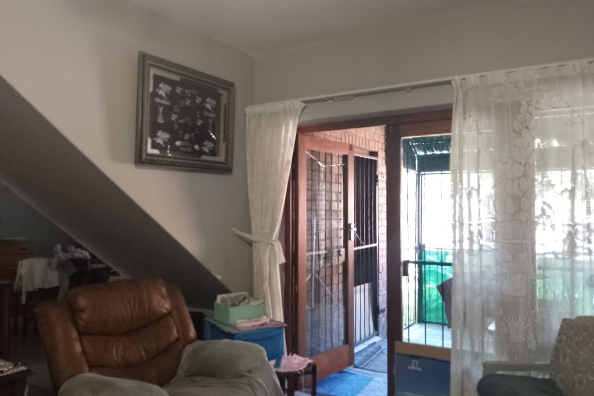 Living room area featuring a sliding glass door with security gate leading to an outdoor space.