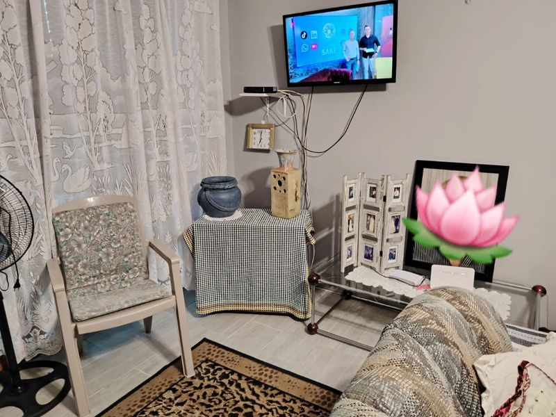 A living room area featuring tiled flooring and neutral wall finishes, providing a functional space for relaxation.
