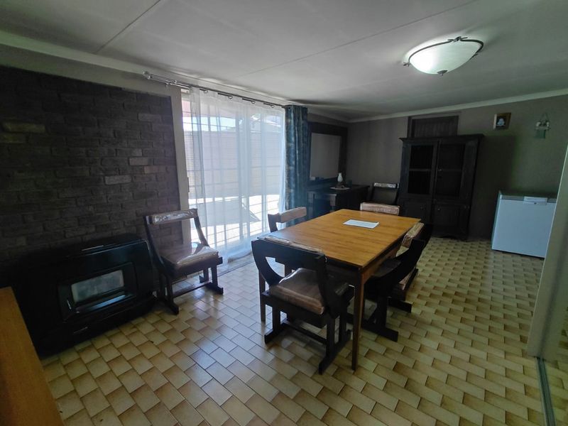 Dining area featuring an exposed brick wall, tiled flooring, and sliding glass doors providing access to the outdoor space.