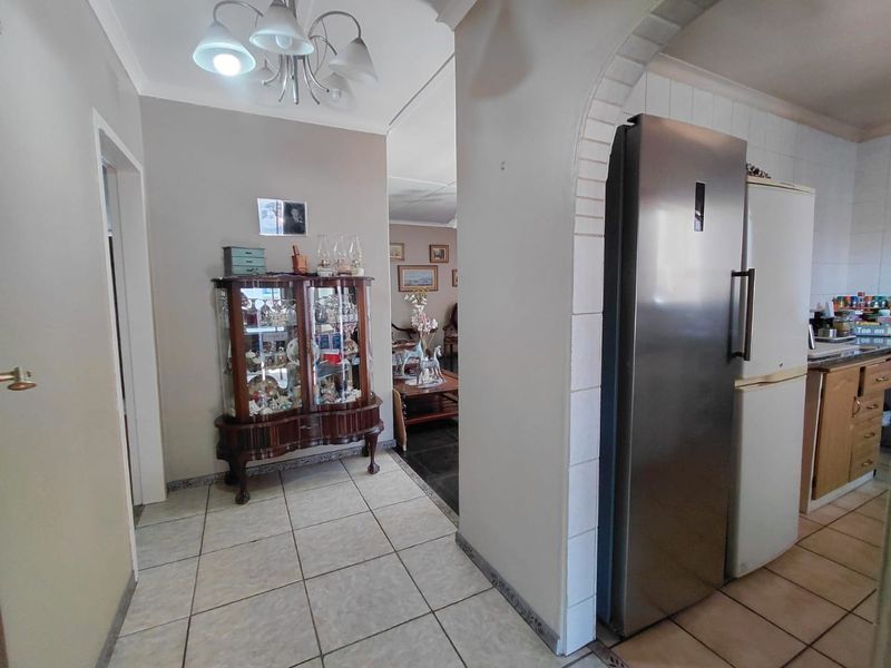 A functional kitchen area featuring tiled flooring, an arched entryway, and built-in cabinetry, providing a practical layout for daily use.