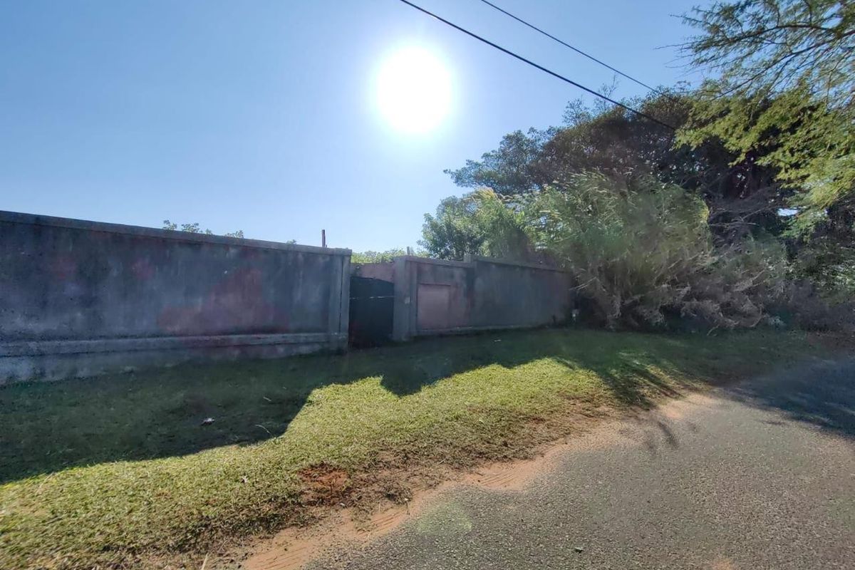 Street view of the property showing a perimeter wall and pedestrian gate access point.