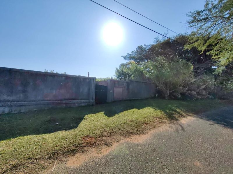 Street view of the property showing a perimeter wall and pedestrian gate access point.
