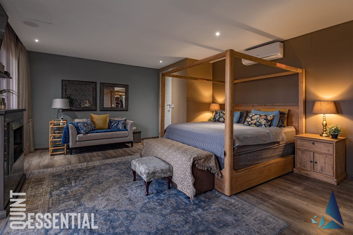 Spacious bedroom featuring wood-look flooring, recessed ceiling lighting, and a wall-mounted air conditioning unit.