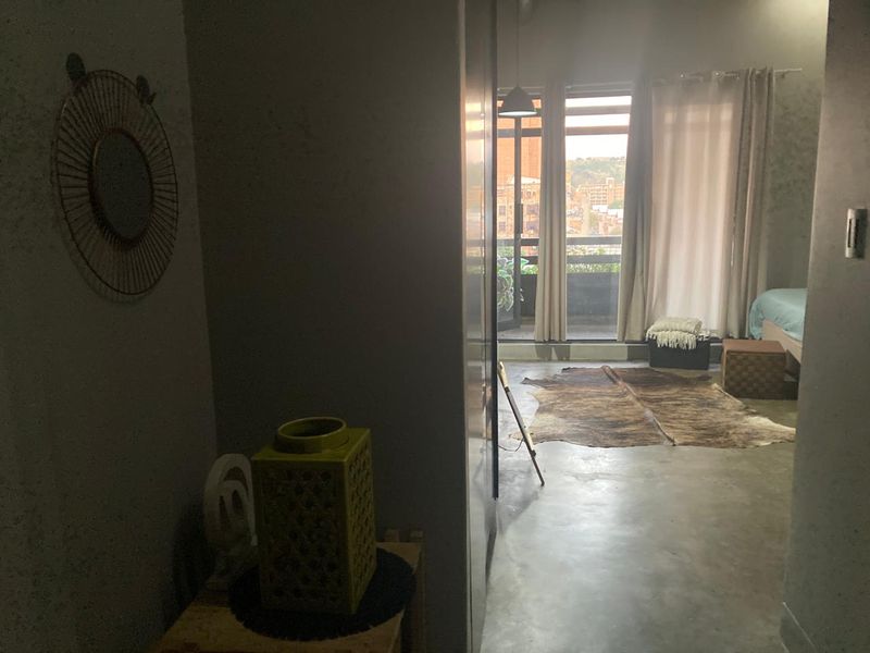 Bedroom featuring polished concrete flooring and direct access to a private balcony through sliding glass doors.