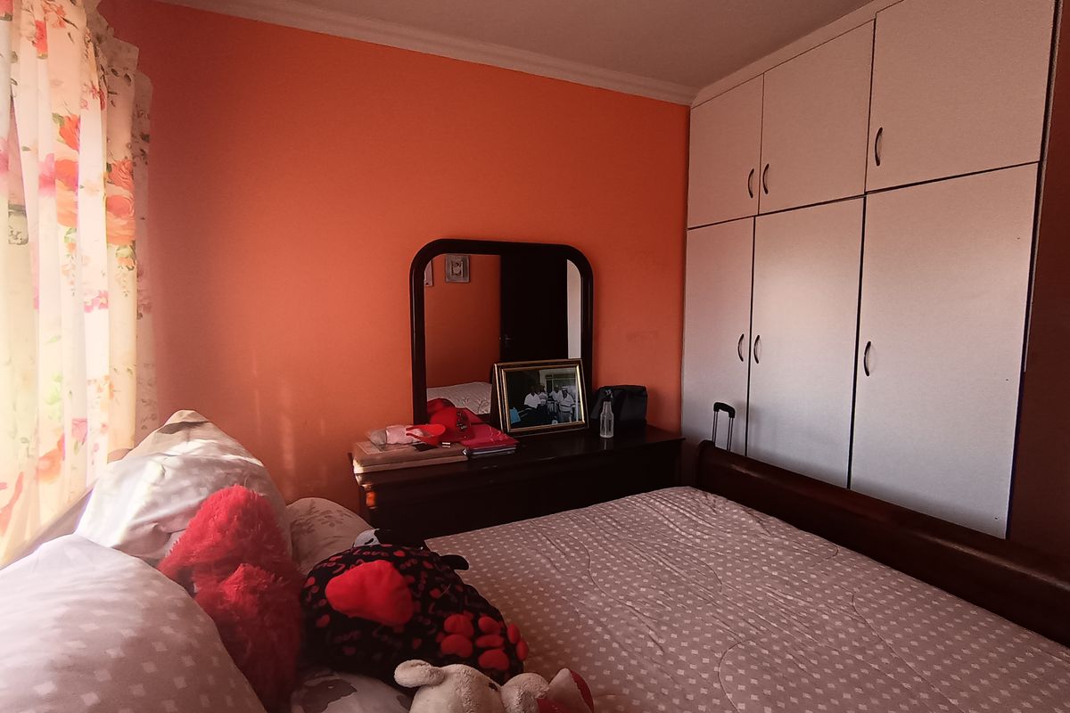 A bedroom featuring built-in cupboards and coving, providing functional storage space within the room.