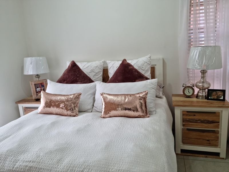 A well-maintained bedroom featuring tiled flooring and window blinds, providing a comfortable and functional sleeping space.