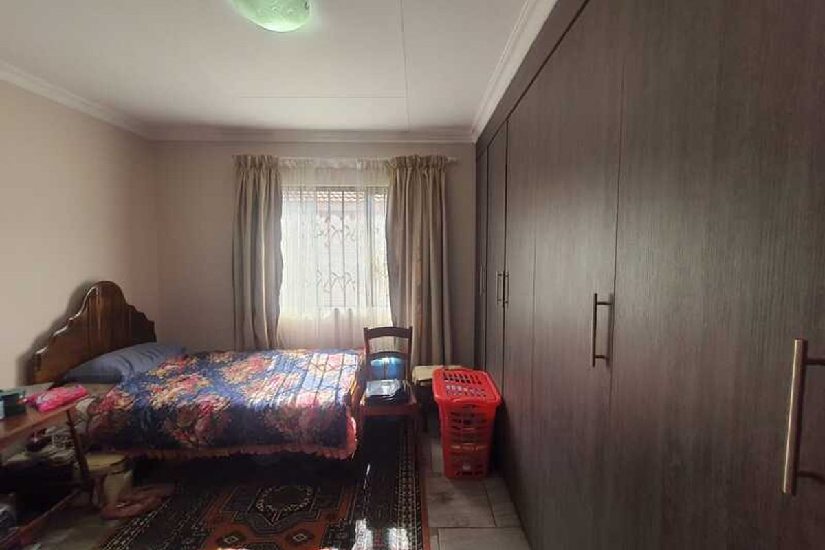 A bedroom featuring extensive floor-to-ceiling built-in wooden cabinetry and tiled flooring.