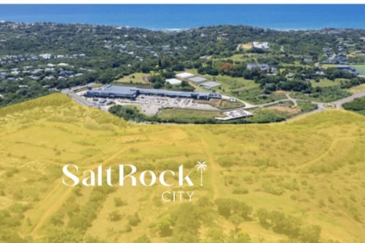 An aerial view of a large undeveloped land parcel in Salt Rock, showcasing the surrounding coastal landscape and nearby commercial infrastructure.
