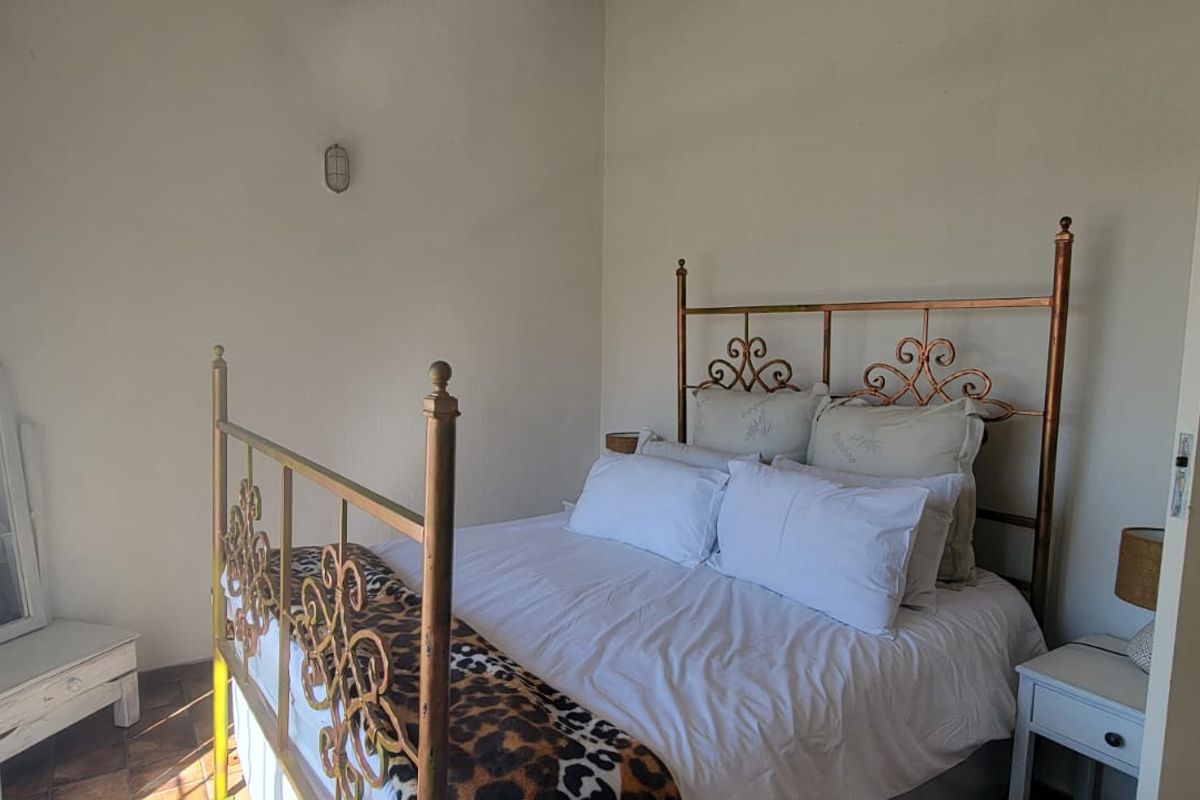 A bedroom featuring tiled flooring and a wall-mounted light fixture.
