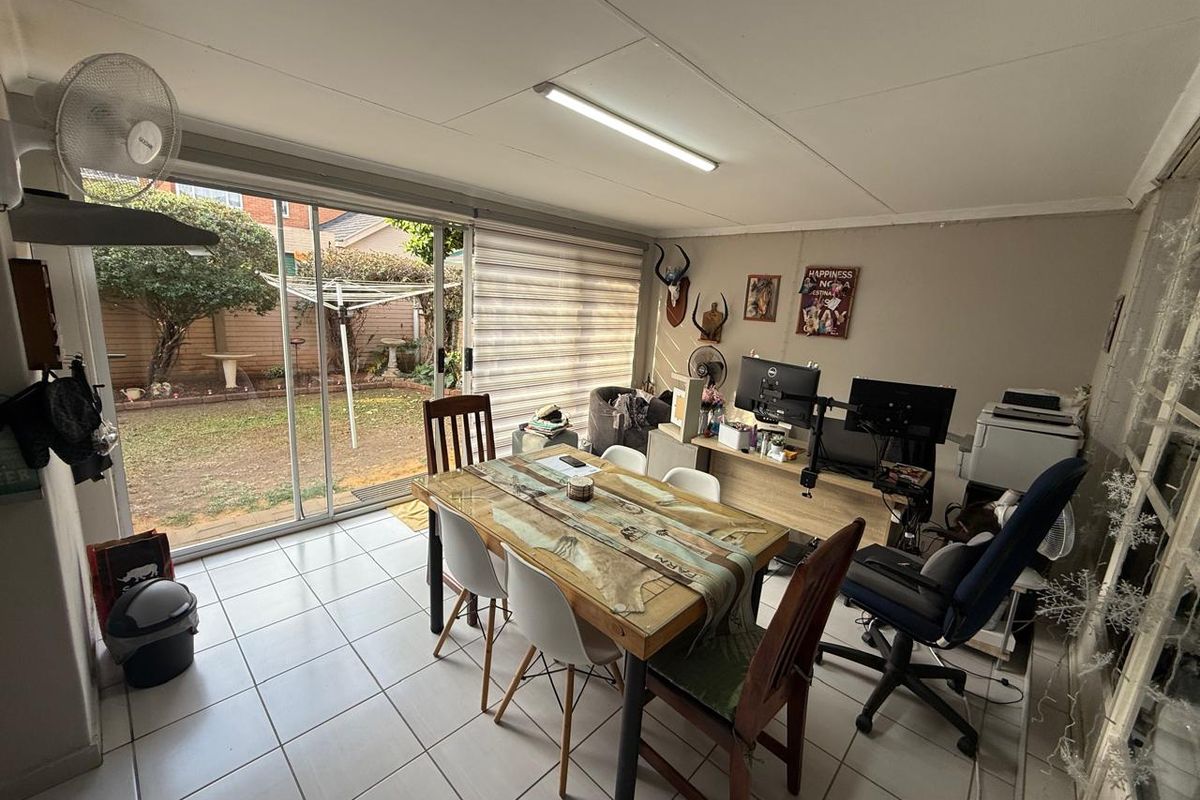 A multi-purpose living area featuring tiled flooring and large sliding glass doors providing direct access to the rear garden.