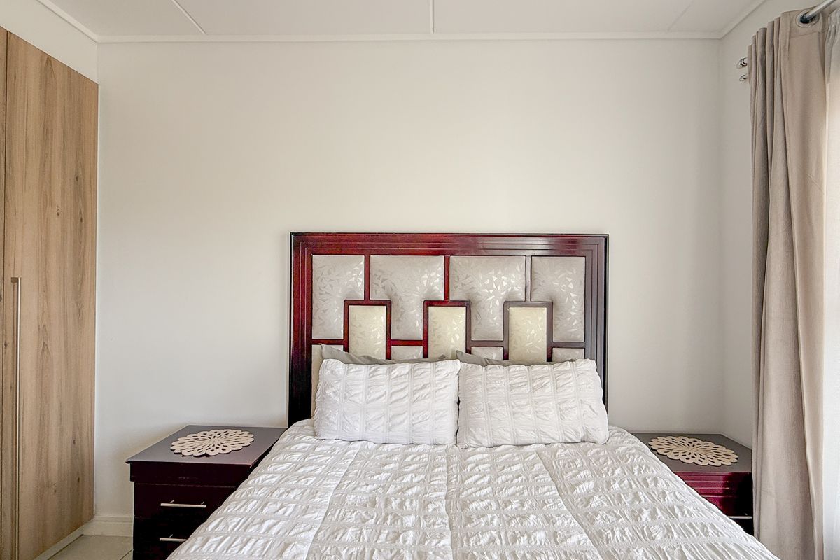 A well-maintained bedroom featuring built-in wooden cabinetry and neutral wall finishes, providing a clean and functional living space.