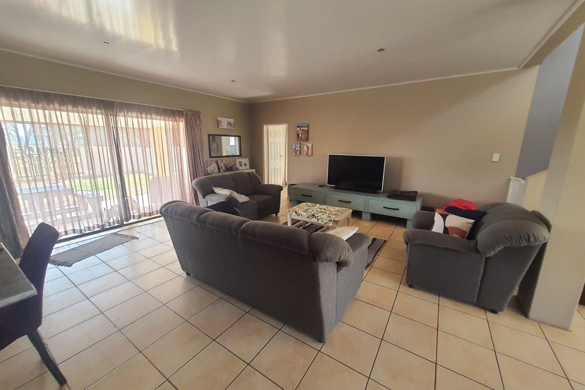 Spacious living room featuring large sliding glass doors that provide natural light and direct access to the outdoor patio area.