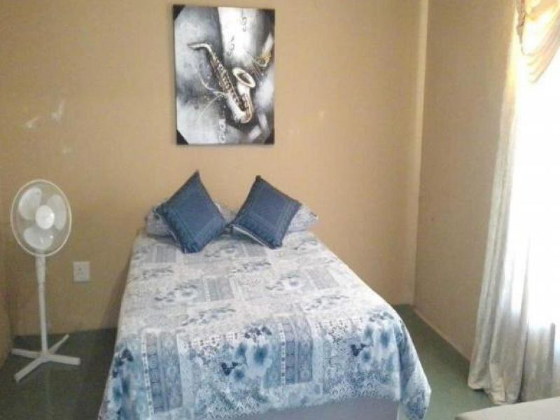 A standard bedroom featuring neutral wall tones and tiled flooring, providing a functional and comfortable living space.