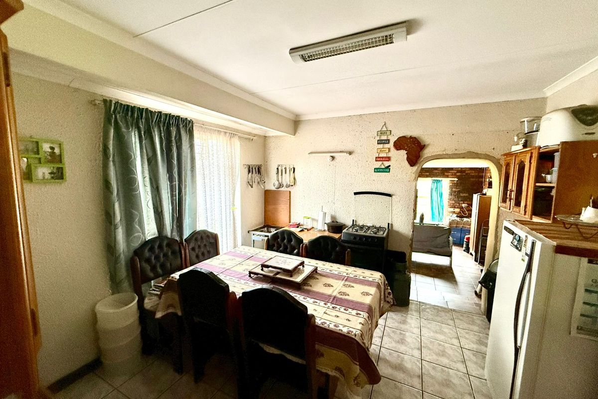 A functional kitchen area featuring tiled flooring, a gas stove, and an arched doorway leading to an adjacent space.
