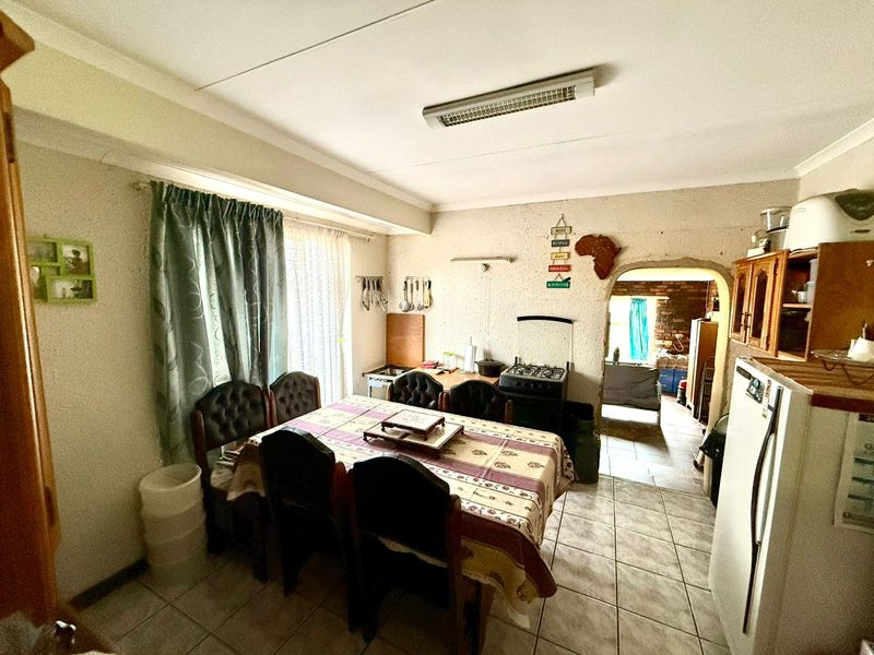 A functional kitchen area featuring tiled flooring, a gas stove, and an arched doorway leading to an adjacent space.